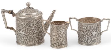 A late 19th century Indian white metal three piece tea set, in the manner of Oomersee Mawjee, Bhuj,