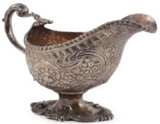 An early George III silver pedestal sauceboat, maker ?B, with gadrooned border and later embossed