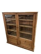 A late 19th century glazed pine bookcase, width 122cm, depth 24cm, height 139cm