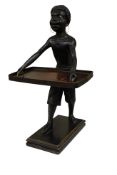 A blackamoor figure with glass eyes, holding a Japanese lacquered tray, 47cm high