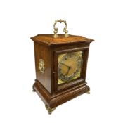 An early 20th century brass mounted oak bracket clock the silvered chapter ring with indistinct