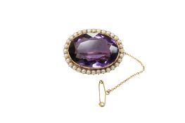 A late Victorian yellow metal mounted single stone oval cut amethyst brroch, with seed pearl set