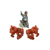 A Chinese figural study of a warrior and two porcelain dogs of Foo, largest 29cm (3)