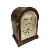 An early 20th century mahogany arched chiming mantel clock with silvered dial, with pendulum and
