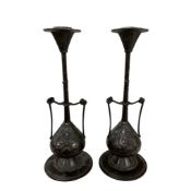 A pair of French bronze candlesticks of classical design, decorated with masks and ivy leaves,