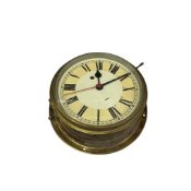 A brass bulkhead ship's timepiece with key, 27cm in diameter