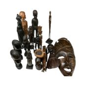 A group of West African ebony and hardwood carved figures and heads, together with a wall mask.