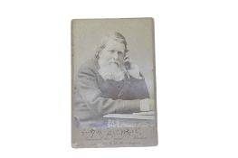 Ruskin, John. cabinet photo. seated at a table and signed beneath - 