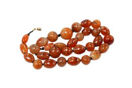 A single row two colour graduated simulated cherry amber oval and circular bead necklace, approx.