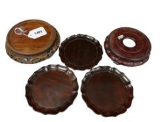 Three Chinese Zitan dishes and two carved hardwood stands, largest 18cm in diameter