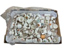 A collection of crested China to include miniature jugs, a chamber stick and mugs