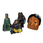 A Chinese terracotta figure of a seated dignitary, two other figures and a Chinese pained wood mask,
