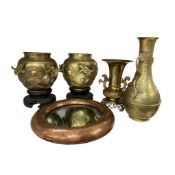 Four pieces of Chinese brass to include a pair of early 20th bowls on stands, decorated in relief