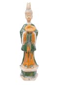 A Large Chinese sancai glazed figure of an attendant, possibly Tang dynasty, 50cm high