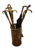A gilt metal cylindrical mesh stick stand holding seven Victorian silver and white metal mounted