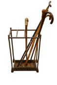 A Victorian brass mounted cast iron stick stand and six walking sticks and canes, one silver