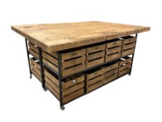A large industrial style oak and steel work table with glass top, each side fitted with drawers on
