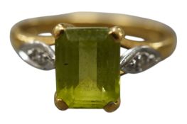 A peridot and diamond ring, claw-set with a step-cut peridot weighing approximately 1.50 carats,