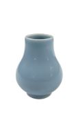 Small pale blue glazed ceramic vase, bulbous body with narrow neck and circular foot, 6cm high.
