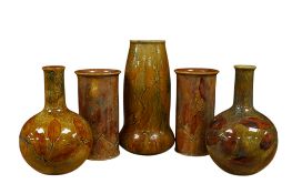 A pair of Doulton Lambeth Autumn Leaves pattern vases, a near pair of similar baluster vases and one