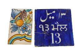 An Islamic square tile with script and a Spanish tile, largest 22 x 22cm