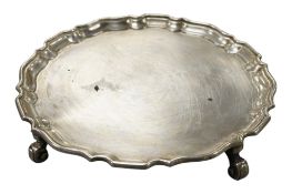 A George V silver waiter, on four scroll feet, Hawksworth, Eyre & Co, London,1929, diameter 15cm,