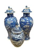 A pair of Chinese blue and white prunus vases and covers and a landscape painted lidded vase, all