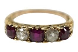 An early to mid 20th century yellow metal, three stone ruby and two stone diamond set half hoop