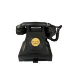 A vintage black Bakelite telephone, with original dial label "Brighton 204803" and pull-out brass