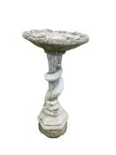 A reconstituted stone garden bird bath with coiled dolphin stem, diameter 48cm, height 94cm