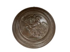 A bronze circular plaque depicting St George slaying the dragon, after Pistrucci, diameter approx.