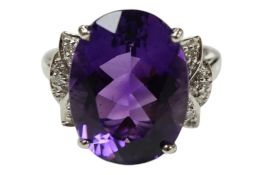 A recent 9ct white gold and single stone oval cut amethyst set dress ring, with diamond chip set