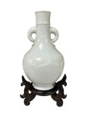 A Chinese white glazed two handled bottle vase, late 19th/early 20th century, wood stand, total