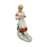 A Russian / Ukrainian porcelain figure of a woman, in folk costume, 30cm high