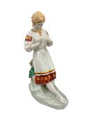 A Russian / Ukrainian porcelain figure of a woman, in folk costume, 30cm high