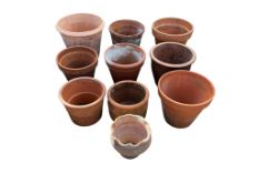 Ten terracotta pots, largest diameter 32cm, height 26cm