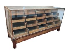 A mid century oak haberdashery cabinet,glass cracked on one end, width 183cm, depth 60cm, height