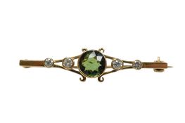 A yellow metal, single stone tourmaline and four stone diamond set bar brooch, 44mm, gross weight
