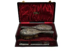 A late Victorian cased pair of repousse silver mounted hair brushes by William Comyns, London, 1896,