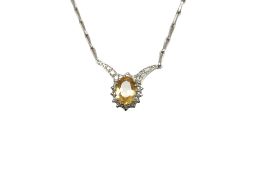 A white metal, tests as platinum, yellow topaz and diamond set pendant necklace, overall 40 cm,