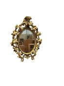 A mid 20th century Florentine giltwood oval wall mirror, width 54cm, height 68cm