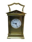 A late 19th century brass carriage clock, with white enamel dial and Arabic numerals, pediment top