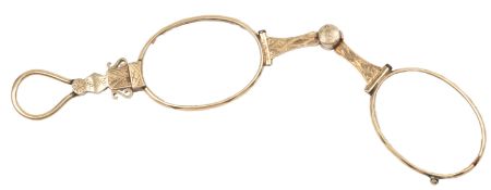 A Victorian gold lorgnette, circa 1868, decorated with foliate engraving, with a spring-loaded
