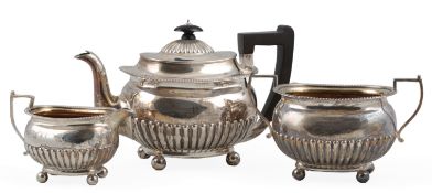 A late Victorian demi-fluted silver three piece tea set by Martin, Hall & Co, of oval form, on
