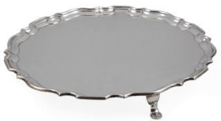 A George V silver salver by Hawksworth, Eyre & Co, of shaped circular form with pie crust border, on