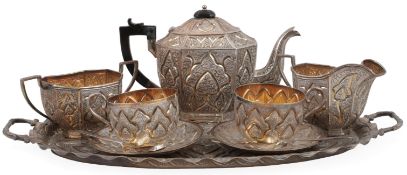An Indian Colonial Kashmir white metal tea service, comprising a two handled shaped oval tea tray, a