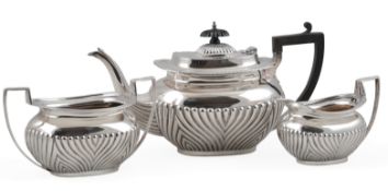 An Edwardian demi-fluted silver three piece tea set by James Deakin & Sons, of oval form, Sheffield,