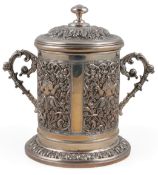 An early 20th century Indian white metal two handled cylindrical jar and cover, embossed with panels