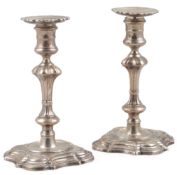A pair of George II cast silver candlesticks by William Gould, with later? associated unmarked
