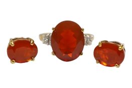 A recent 9ct gold and single stone oval cut fire opal set ring, with diamond set shoulders, size N/O